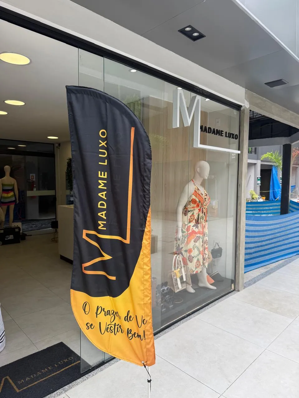 Entrada da loja Madame Luxo com wind banner personalizado